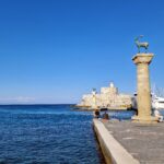 The Stag and Doe statues atop the pillars of the Colossus with St. Nicholas Fortress in the background